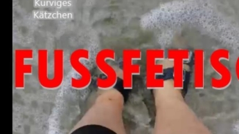 Kleine Füße in Sandalen im Meer