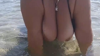Nackte Brüste am öffentlichen Strand. Nasse dicke Titten